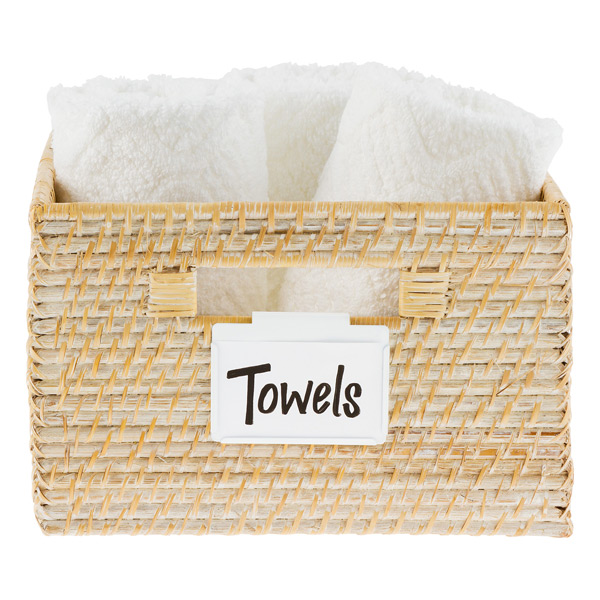 A close up of a basket filled with white towels. Label on basket says Towels