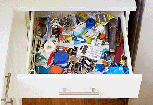 an open drawer with unorganized items